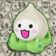 A anime keychain sits on top of a large pile of money.
